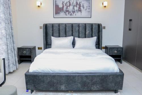 Un dormitorio con una cama grande con dos mesitas de noche. en Sweetwaters Holiday Home Nanyuki, en Nanyuki