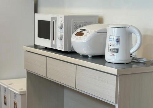 a kitchen counter with a microwave and a toaster at MomodaniHome地铁口旁JR大阪环状线近奈良溫馨家庭地暖一户建直达梅田天王寺大阪城公园 in Osaka