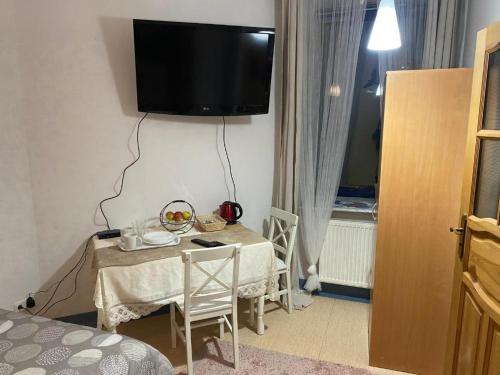 a room with a table with a television on the wall at Arkuszowa 58 Apartament 5 in Warszawa