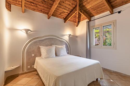 une chambre avec un grand lit avec des draps blancs dans l'établissement Domaine Pietra di Sole, à Porto-Vecchio