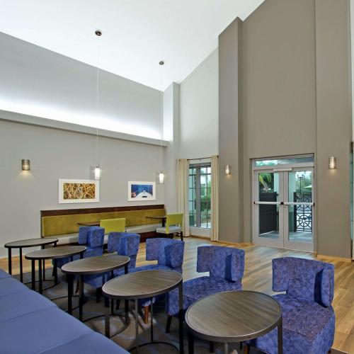 a waiting room with tables and blue chairs at Homewood Suites by Hilton Fort Lauderdale Airport-Cruise Port in Dania Beach