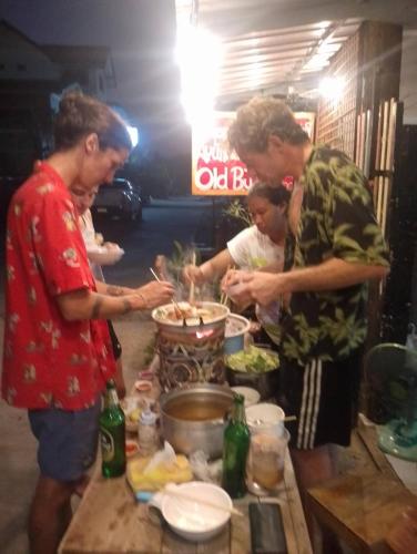 a group of people standing around a table preparing food at Ayutthaya Par Plearn Homestay อยุธยา พาเพลินold BJ Guesthouse in Phra Nakhon Si Ayutthaya