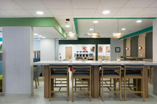 a restaurant with a bar with stools at Hampton by Hilton Saltillo Zona Aeropuerto in Saltillo