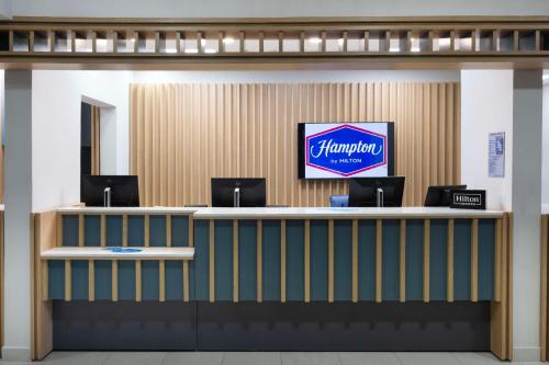 a lobby with a counter with a pharmacy sign on it at Hampton by Hilton Saltillo Zona Aeropuerto in Saltillo