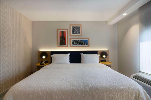 a bedroom with a large white bed with two lamps at Hampton by Hilton Saltillo Zona Aeropuerto in Saltillo