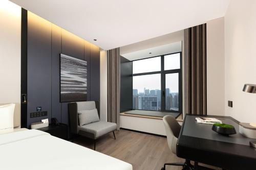 a bedroom with a bed and a desk and a chair at Atour Hotel Shanghai Wujiaochang Wanda Plaza in Shanghai