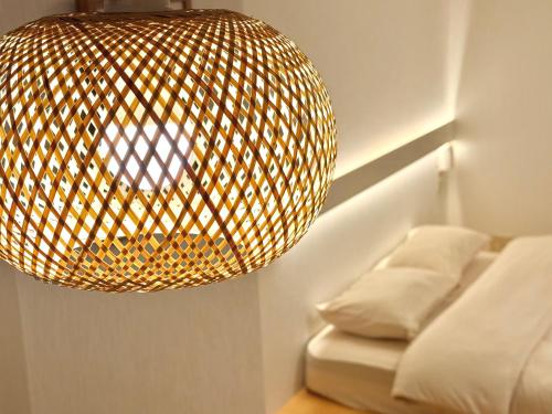 a large light fixture hanging over a bed at 桜南大塚ハウス i in Tokyo