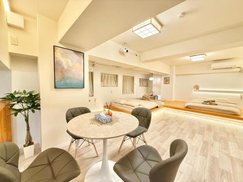 a living room with a table and chairs and a bed at 桜南大塚ハウス i in Tokyo