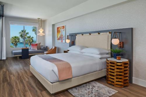 a bedroom with a large bed and a living room at Mission Pacific Beach Resort, part of JdV by Hyatt in Oceanside