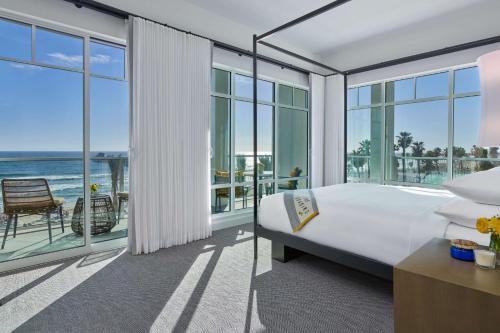 a bedroom with a bed and a view of the ocean at The Seabird Ocean Resort & Spa, Part of Destination Hotel by Hyatt in Oceanside