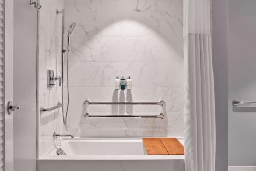 a white bathroom with a tub and a sink at The Seabird Ocean Resort & Spa, Part of Destination Hotel by Hyatt in Oceanside