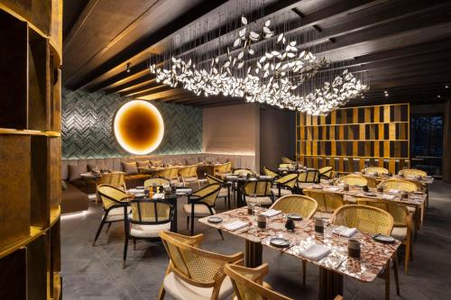 a restaurant with tables and chairs and a chandelier at Waldorf Astoria Costa Rica Punta Cacique in Playa Hermosa