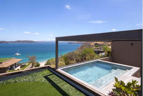 a view of the ocean from a house with a swimming pool at Waldorf Astoria Costa Rica Punta Cacique in Playa Hermosa
