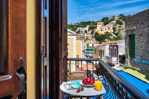a table on a balcony with a view of a city at Ilioni Apartment in Symi