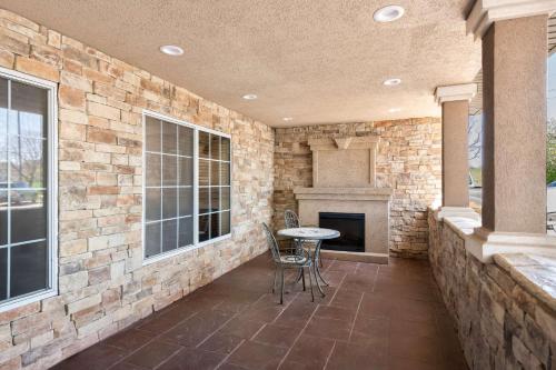 a patio with a table and chairs and a fireplace at Country Inn & Suites by Radisson, Topeka West, KS in Topeka