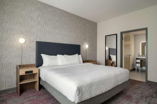 a hotel room with a large bed and a mirror at Home2 Suites By Hilton Conyers Atlanta in Conyers