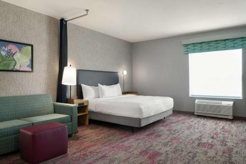 a hotel room with a bed and a couch at Home2 Suites By Hilton Conyers Atlanta in Conyers