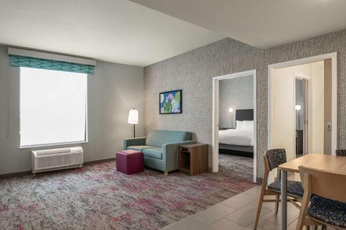 a living room with a couch and a bed at Home2 Suites By Hilton Conyers Atlanta in Conyers