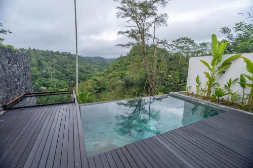 a plunge pool in a resort with a view of the forest at Micaela Bali Ubud Villas in Tegalalang