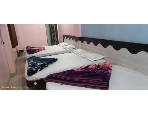 a couple of beds sitting in a room at Hotel Manya inn, Omkareshwar in Godarpura