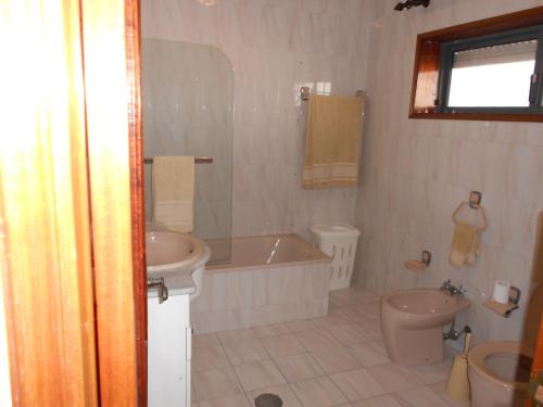 a bathroom with a tub and a toilet and a sink at Vila do Conde Holidays Flat in Areia