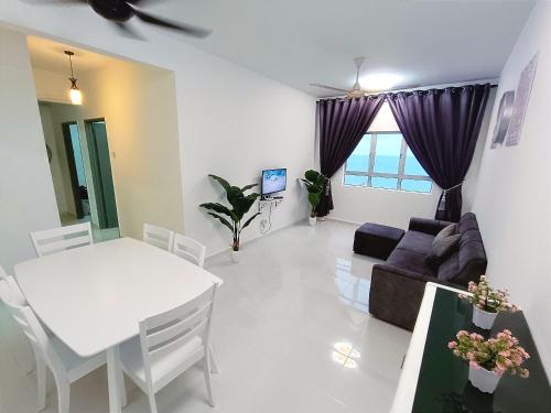 a living room with a white table and a couch at D'luna Homestay Terengganu SeaView in Kuala Terengganu