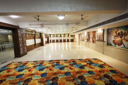 a large room with a colorful quilt on the floor at Shanti Sewa Dham in Chhatikara