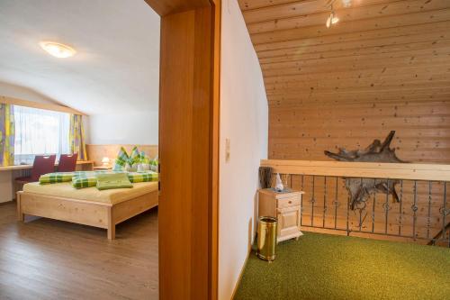 a bedroom with a bed and a wooden wall at Landhaus Vier Jahreszeiten in Krimml