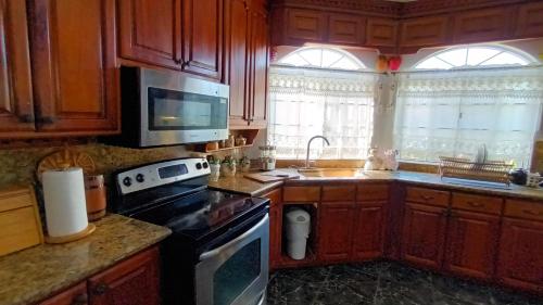 a kitchen with wooden cabinets and a stove top oven at Sukasa Ville in Montego Bay