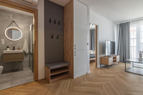 a bathroom with a shower and a sink and a mirror at Apartament Bulwary 36 in Oświęcim