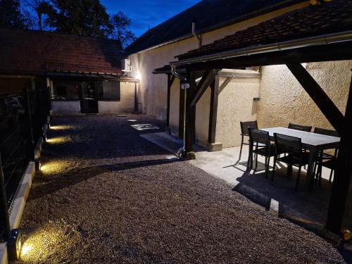 un patio avec une table et des chaises dans un bâtiment dans l'établissement maison 6 personnes, à Bruère-Allichamps