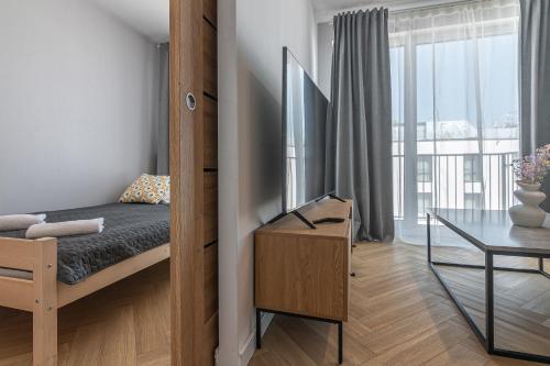 a bedroom with a bed and a table and a window at Apartament Bulwary 36 in Oświęcim