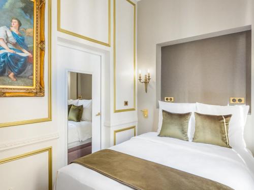 une chambre avec un lit et un tableau au mur dans l'établissement Merveil - Luxury Serviced Apartment - Aboukir VI, à Paris