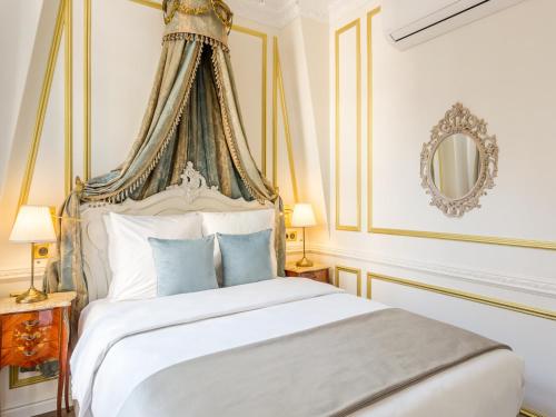 une chambre avec un lit blanc à baldaquin dans l'établissement Merveil - Luxury Serviced Apartment - Aboukir VI, à Paris