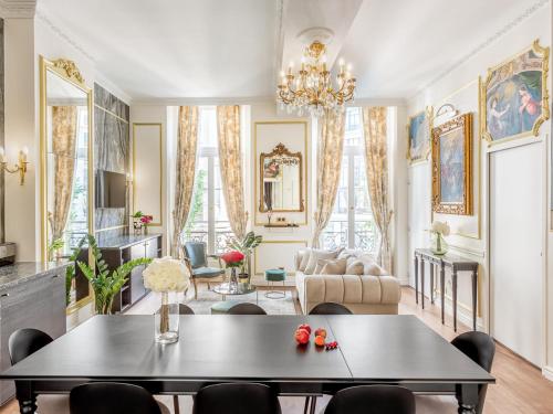 un salon avec une table et des chaises dans l'établissement Merveil - Luxury Serviced Apartment - Aboukir VI, à Paris