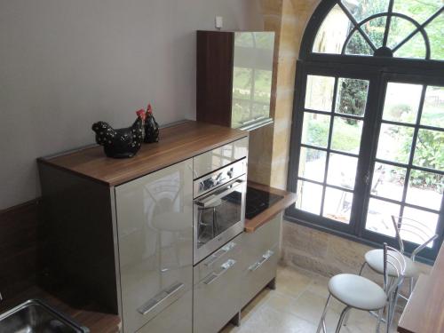 a kitchen with a stainless steel stove and a window at La Rebière d'Or, B&B et Gîte in Mouleydier
