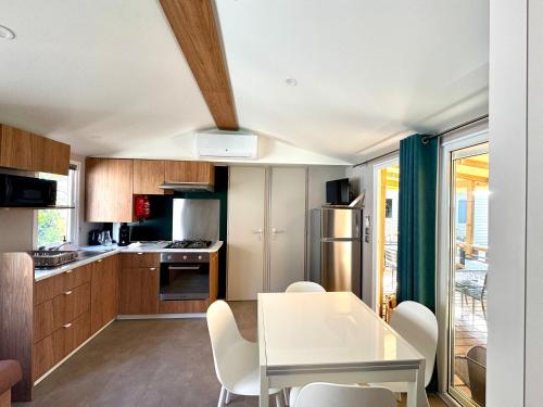 a kitchen with a white table and chairs at Bungalow Casita in Lège-Cap-Ferret