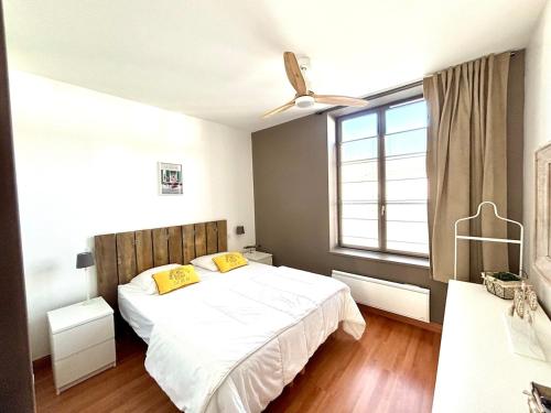 - une chambre avec un grand lit blanc et des oreillers jaunes dans l'établissement Charme et confort dans St Martin de Ré terrasse & parking, à Saint-Martin-de-Ré