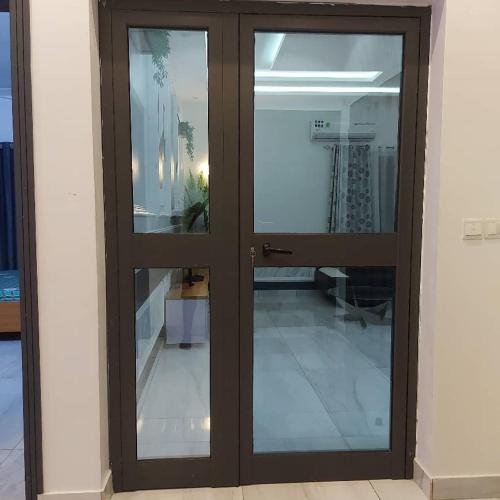 a pair of glass doors in a room at Appartement meublé haut standing in Kika