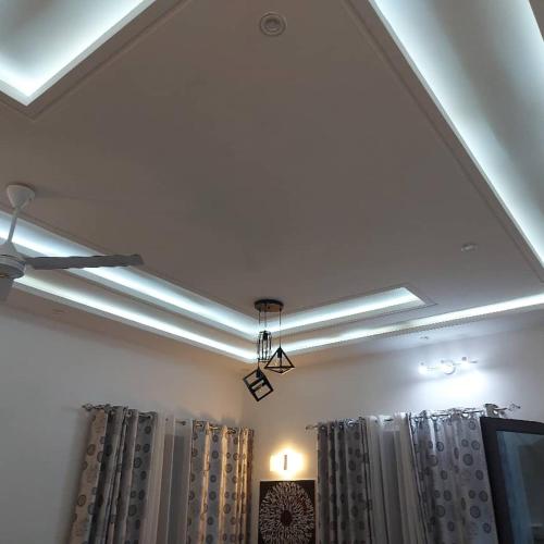 a row of fluorescent lights on a ceiling with curtains at Appartement meublé haut standing in Kika
