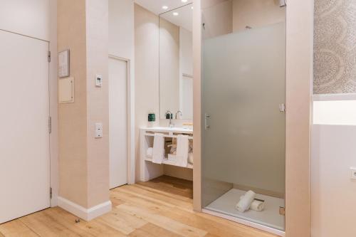 a bathroom with a mirror and a sink at Melia Plaza Valencia in Valencia