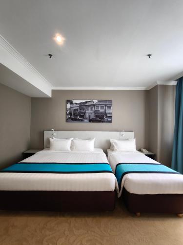 two beds in a bedroom with blue and white at Alamis City Kuala Lumpur - Formerly EDC Hotel Kuala Lumpur in Kuala Lumpur