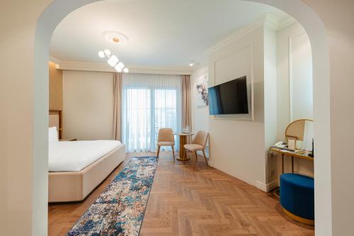 a hotel room with a bed and a desk and a tv at SunGarden Golf & Spa Resort in Cluj-Napoca