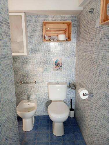 a bathroom with a white toilet and a sink at La Terrazza dei Santi in Lucca
