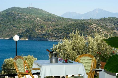 a table and chairs with a view of the ocean at Kerveli Village Hotel in Kerveli