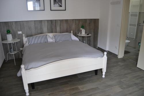 a white bed in a room with two tables at B&B Residenza Marina in Marina di Carrara