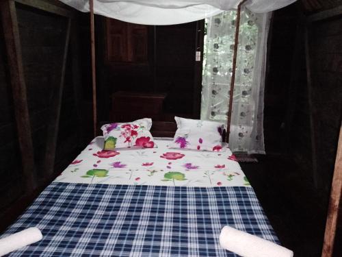 a bed with flowers on it in a room at Masoala bungalows in Maroantsetra