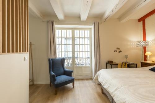 une chambre avec un lit et une chaise bleue dans l'établissement 24h Au Mans, au Mans