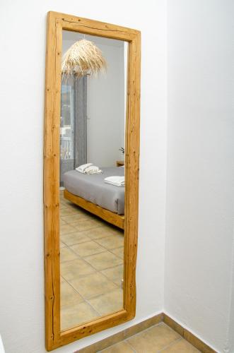 a mirror on a wall with a bed in a room at Hotel Livadia in Parikia