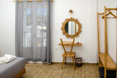 a bedroom with a mirror and a chair at Hotel Livadia in Parikia